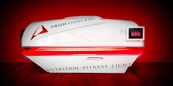 Woman using the Prism Light Pod for full-body red light therapy at Revive Wellness & Beauty in Powell, Ohio